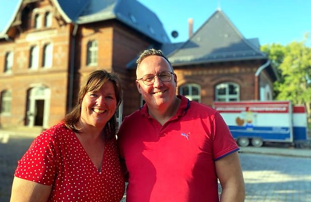 Ik Vertrek-deelnemers Ingrid en Edward voor het oude stationsgebouw in Ballenstedt dat ze gaan opknappen