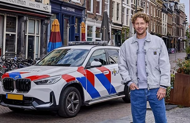 Ewout Genemans bij politiewagen voor Bureau Utrecht.