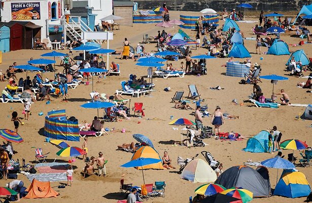 Strandgangers waar zomaar een groot gezin tussen zou kunnen liggen.